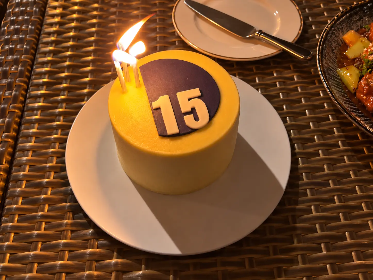 Celebration cake topped with the number 15 and lit candles