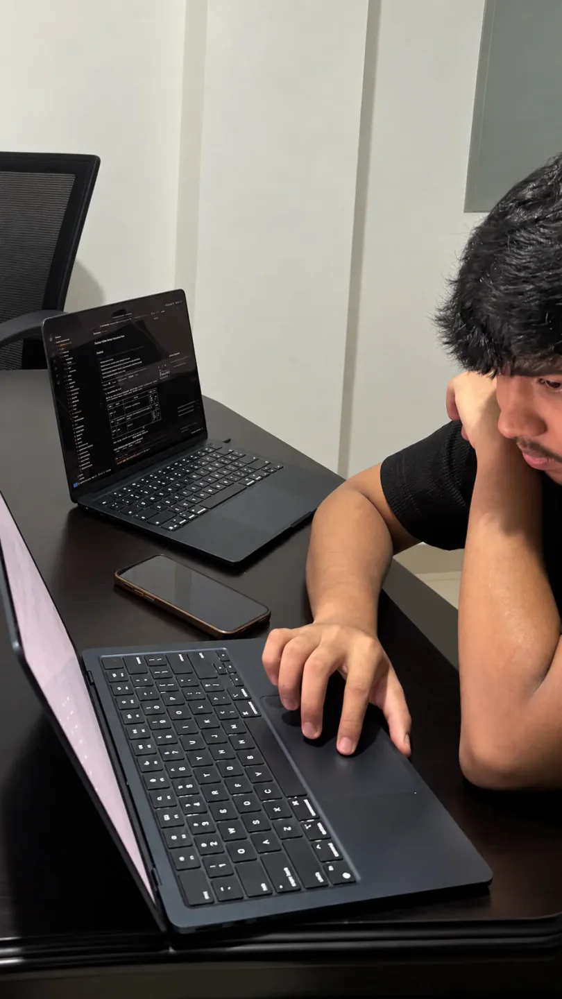 D15 Labs engineer working at a desk with two laptops